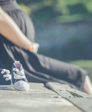 Kobieta w ciąży siedzi na moście