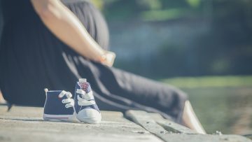 Kobieta w ciąży siedzi na moście